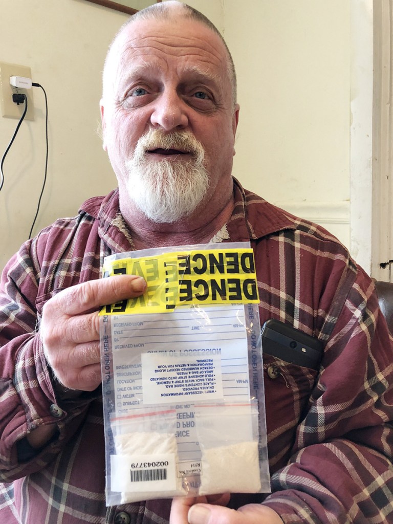 Kevin Curtis holds an evidence bag Tuesday that contains two clear pouches filled with the ashes of his late father, Robert C. Curtis Sr. The smaller bags had been seized as suspected heroin by Kennebec County sheriff's deputies after a car crash Saturday in Manchester. Kevin Curtis had lent his car to a friend to go to the grocery store, and the remains were in the glove box.