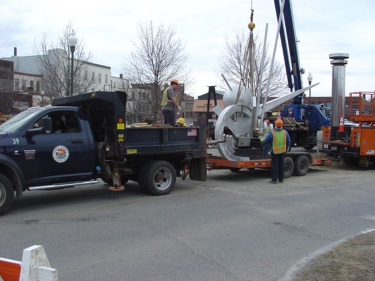 Members of a Waterville public works crew secure the crown of "The Ticonic" sculpture on a trailer. The top part of the sculpture was taken to the Public Works Department, where it will be kept until it can be reunited with its pedestal at Head of Falls.