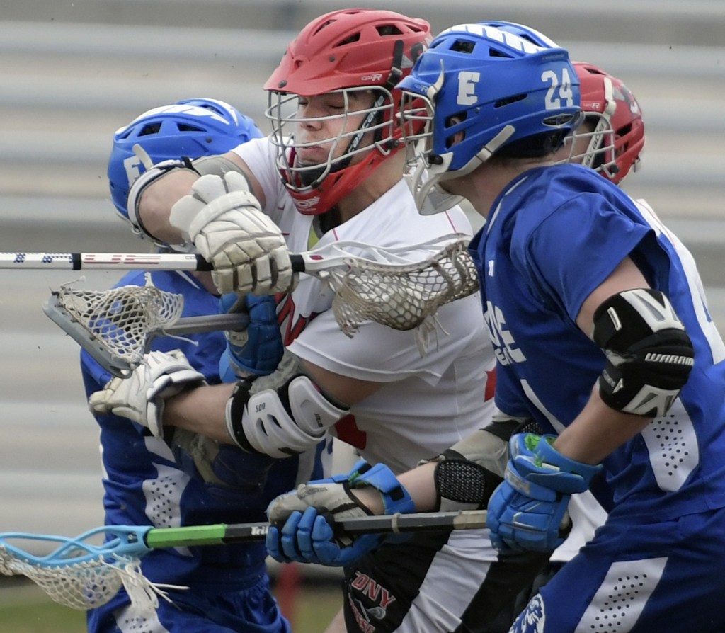 Cony's Nic Mills, center, crashes through Erskine defenders during a lacrosse match Wednesday in Augusta.
