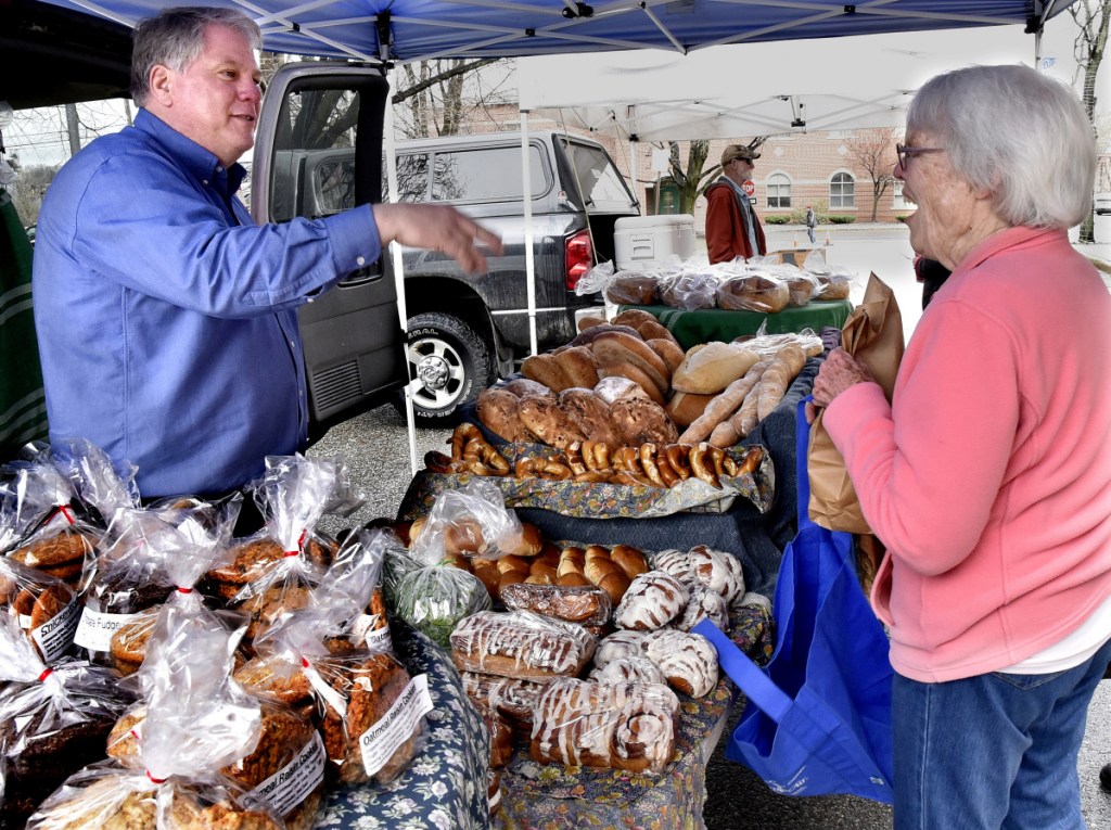 Karl Rau, of Good Bread, speaks with customer Kathleen Bammer on Thursday. The Downtown Waterville Farmers' Market has opened for the season on Common Street in Waterville and will have products for sale every Thursday.