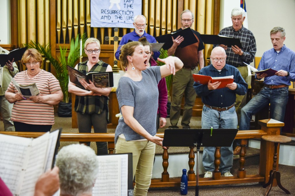 CODA Chorus director Joelle Morris, center, leads rehearsal Monday night in Winthrop. The chorus celebrates its anniversary with two concerts this Saturday at Hope Baptist Church in Manchester. The concert consists of pieces performed from every decade since its inception about 50 years ago.