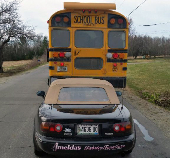 A school bus backed over a Mazda Miata sports car Friday on Industry Road in New Sharon. No injuries were reported.