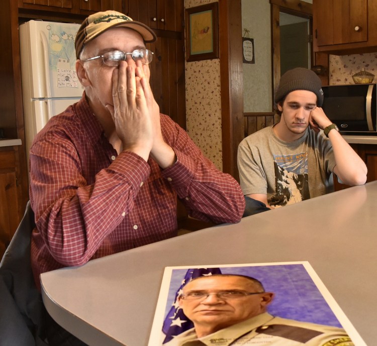 Tom Cole, left, brother of slain Somerset County Deputy Cpl. Eugene Cole, in the photograph, tries to regain his composure while talking about his brother in Skowhegan on Sunday. At right is his son Scott. "He was more than a brother and friend," Tom Cole said. "He was a father figure."