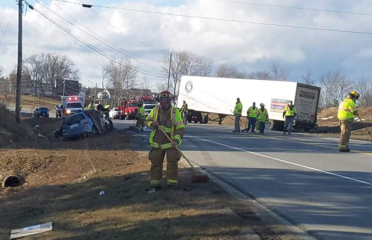 Firefighters clean up at the scene of Monday's fatal crash on Route 1 in Warren.