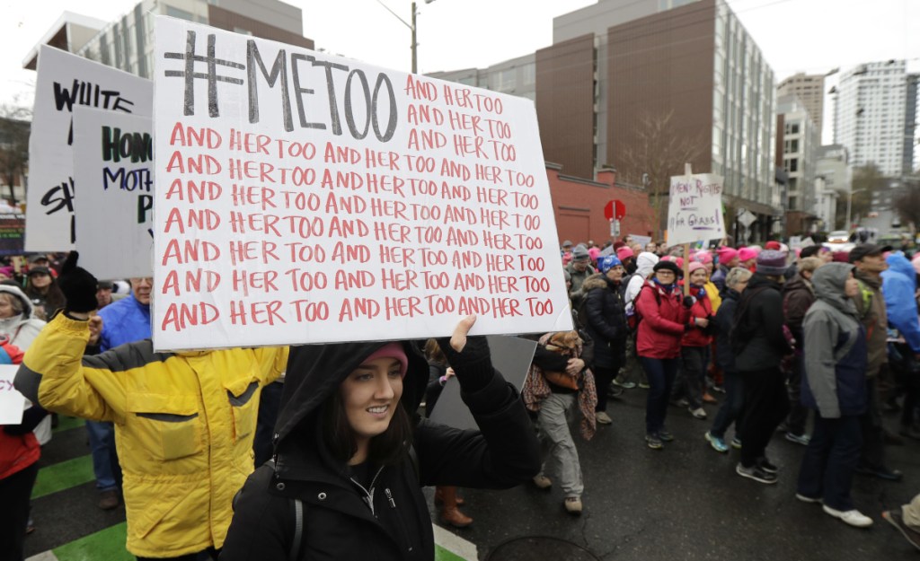 A marcher carries a sign with the popular Twitter hashtag #MeToo during a women's march in Seattle.