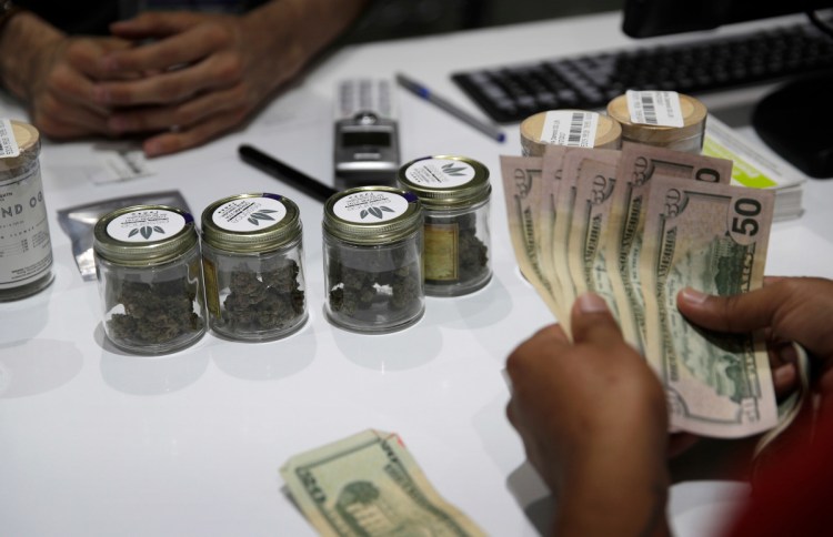 A person buys marijuana at the Essence cannabis dispensary in Las Vegas last year. Many employers across the country are quietly taking what once would have been a radical step: They're dropping marijuana from the drug tests they require of prospective employees.