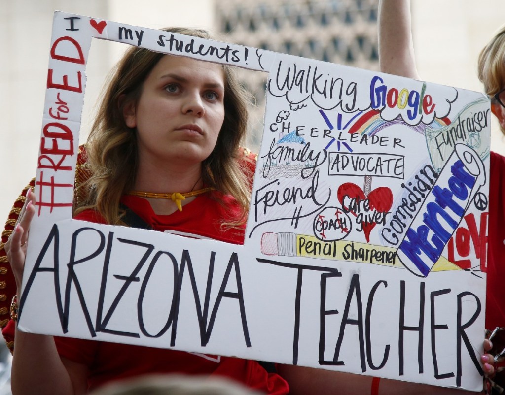 Teacher Taylor Dutro listens as protest organizers announce Arizona teachers' intentions to go back to work if lawmakers pass a school funding plan, during the fourth day of the statewide teachers' strike at the Arizona Capitol on Tuesday in Phoenix. Associated Press/Ross D. Franklin