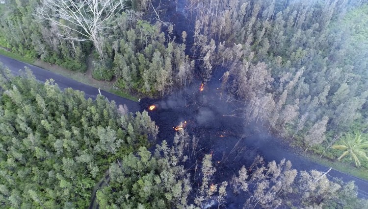 In this still frame taken from video, lava flows over a road in the Puna District as a result of the eruption from Kilauea Volcano on Hawaii's Big Island Friday. The eruption sent molten lava through forests and bubbling up from paved streets and forced the evacuation of about 1,500 people who were still out of their homes Friday after Thursday's eruption.