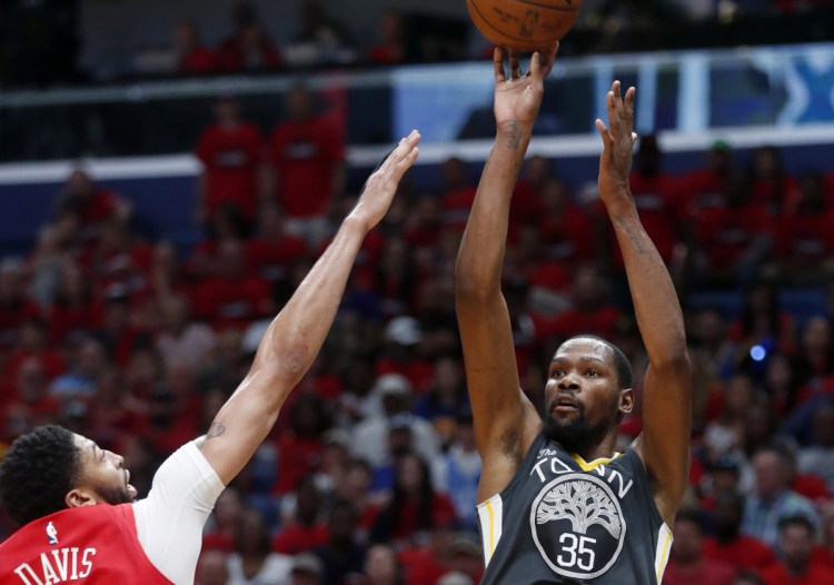 Kevin Durant, who finished with 38 points, lofts a shot over Anthony Davis of the New Orleans Pelicans in the first half of the Golden State Warriors' 118-92 victory Sunday. The Warriors will head home with a 3-1 series lead.