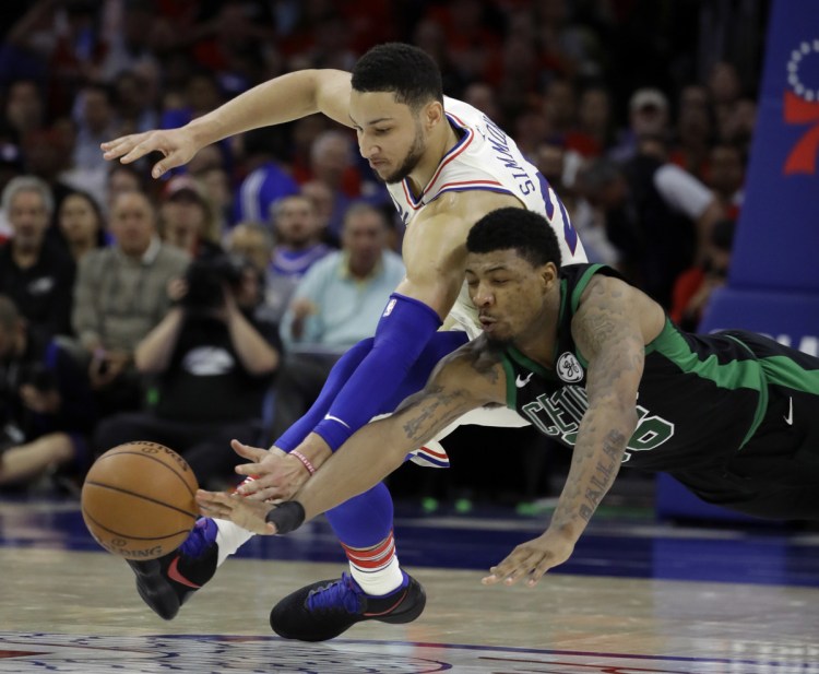Boston's Marcus Smart, right, and Philadelphia's Ben Simmons chase after a loose ball during the first half of the 76ers' 103-92 win in Game 4 of their Eastern Conference semifinal series on Monday in Philadelphia.