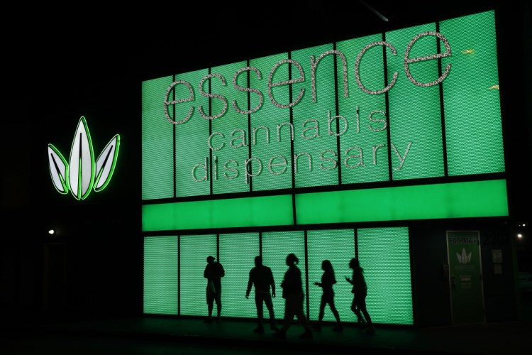 People stand outside after shopping at the Essence cannabis dispensary in Las Vegas.