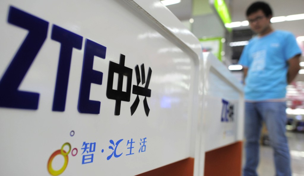 A salesperson stands at counters selling mobile phones produced by ZTE Corp. at an appliance store in Wuhan in central China's Hubei province. The Chinese tech company ZTE has been brought to its knees by the trade dispute.