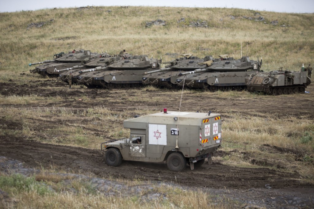 An Israeli military ambulance drives past tanks in the Israeli-controlled Golan Heights, near the border with Syria, on Thursday.