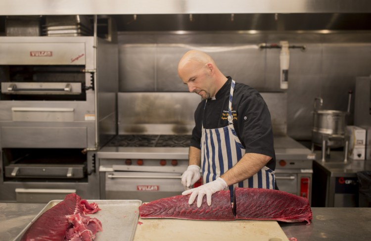 Tim Labonte, the executive regional chef for Maine Properties, breaks down tuna in the kitchen at BlueFin in the Portland Harbor Hotel. The restaurant is in the space formerly occupied by Eve's at the Garden.