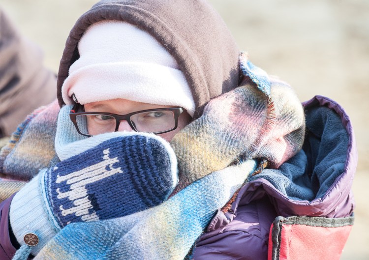 Mandy Hufslader of Dresden keeps bundled up Sunday and watches for a teammate to finish the 100-mile race at Riverlands State Park in Turner.