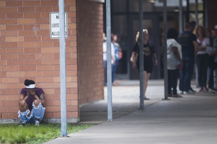 People gather by the Barnett Intermediate School where parents went to pick up their children following a shooting at Santa Fe High School on Friday in Santa Fe, Texas.