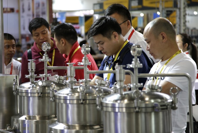 Participants inspect brewing equipment this week at the 2018 Craft Beer of China Exhibition in Shanghai, where brewers networked and shared tips on the latest technologies. A growing middle class in China is shifting from legacy brews to more experimental, refined and expensive beer options.