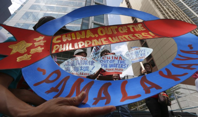 Protesters display placards during a rally at the Chinese consulate in the financial district of Makati city, east of Manila, Philippines. 