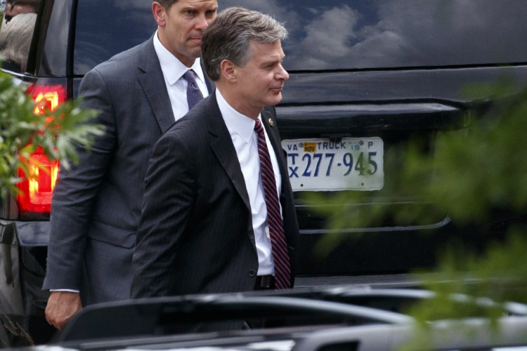 FBI Director Christopher Wray, foreground, leaves the White House after meeting Monday with President Trump amid reports that the agency had an informant who met several times with Trump campaign officials with suspicious contacts linked to Russia.