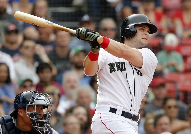 Boston's Andrew Benintendi watches his two-run triple during the seventh inning Saturday against the Atlanta Braves at Fenway Park in Boston.