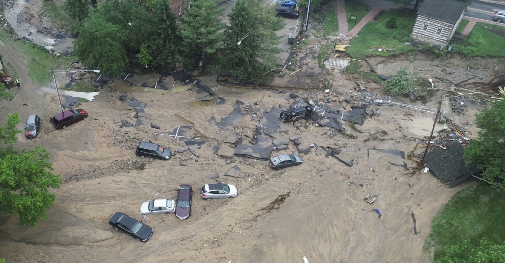 This image made from video provided by DroneBase shows vehicles swept by floodwaters near the intersection of Ellicott Mills Drive and Main Street in Ellicott City, Md., Monday.