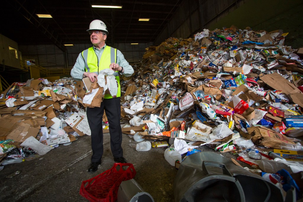 Ecomaine CEO Kevin Roche picks through unsorted materials. "The only variable we can do something about is contamination," Roche said. "We need everyone's help to fix this problem. The next time you go to a recycling bin, ask yourself 'which bin should I put this in?' If you don't know, please find out."
