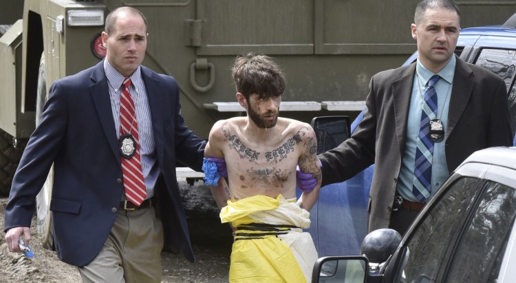 Suspected police-killer John Williams is led by Maine State Police detectives to a cruiser after being arrested Saturday in Fairfield, following a four-day manhunt after he allegedly shot Cpl. Eugene Cole, of the Somerset County Sheriff's Office.