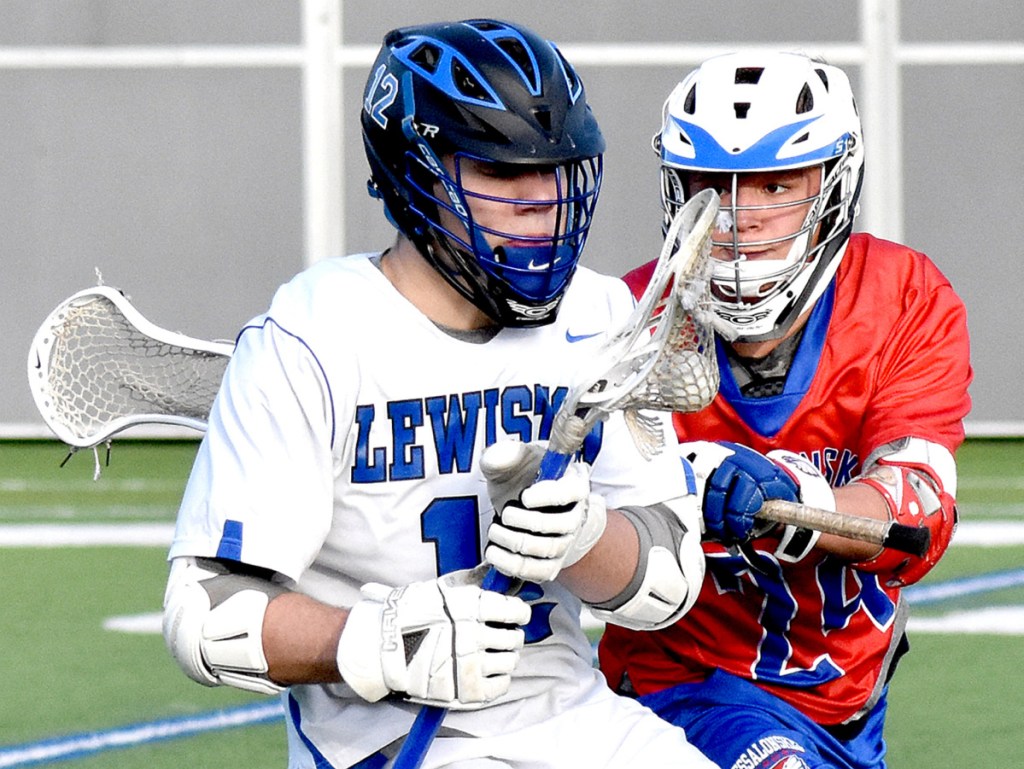 Lewiston high School's Garrett Poussard, left, braces for a hit from Messalonskee's Dan Gusmanov during their game on Garcelon Field at Bates College in Lewiston on Tuesday.