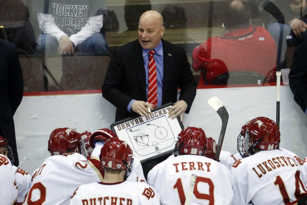 In this March 2017 photo, Denver head coach Jim Montgomery directs his players during a time-out in the second period of the midwest regional final of the NCAA hockey tournament in Cincinnati. A person with knowledge of the situation tells The Associated Press that the Dallas Stars will hire Montgomery to be their next head coach. Montgomery takes over Ken Hitchcock, who retired last month and will become a consultant for the Stars. The person spoke on condition of anonymity Wednesday because the hiring had not been announced.