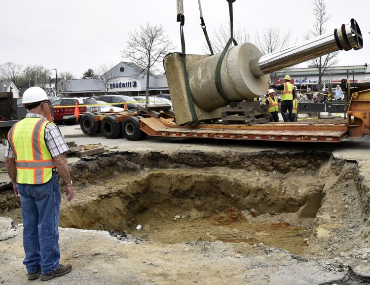 Waterville Public Works Director Mark Turner stands beside a gaping hole Thursday, May 3, in The Concourse in Waterville as a crane crew slowly lowers the base of "The Ticonic" sculpture onto a trailer that later carried the piece to its new site at Head of Falls.