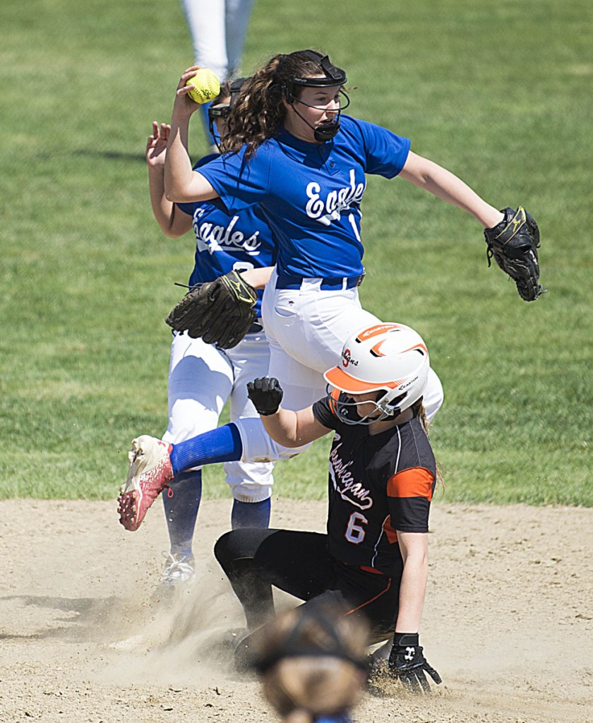 Messalonskee shortstop Taylor Baker, center, leaps over Skowhegan's Sydney Ames (6) as she tries to turn the double play Saturday in Skowhegan.