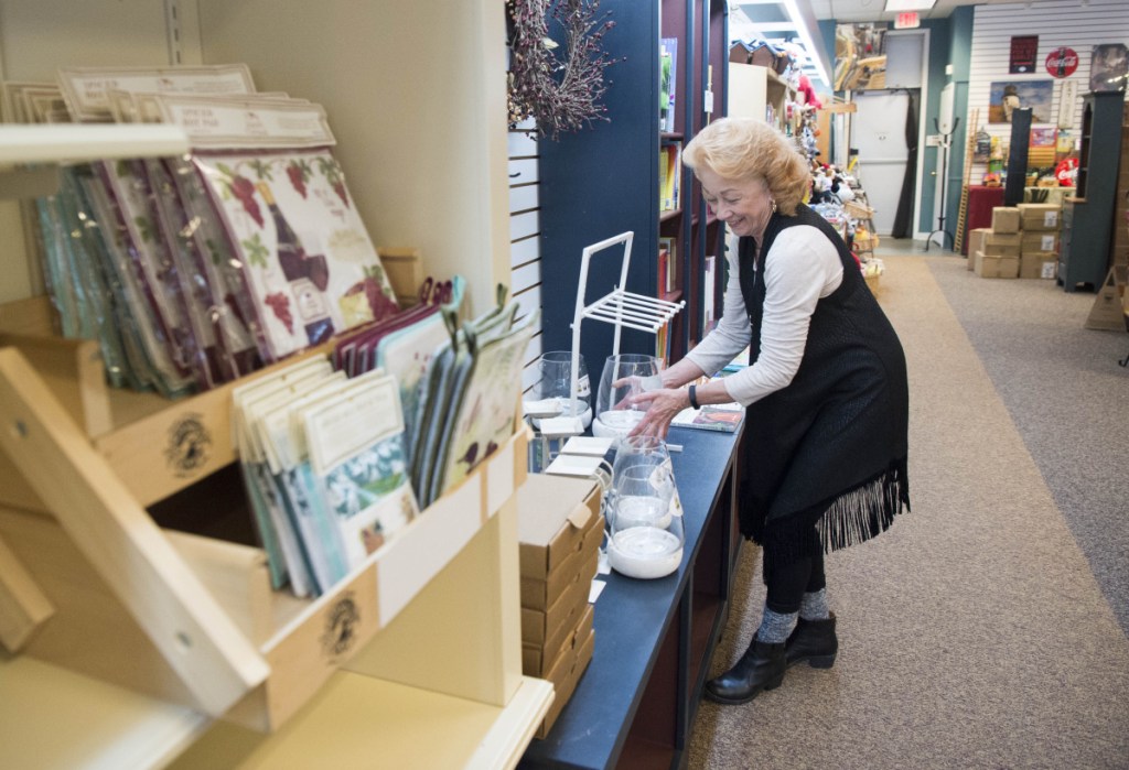 Carla Dumont sets up merchandise at the new location of Maine Made and More at The Concourse in downtown Waterville on Friday.