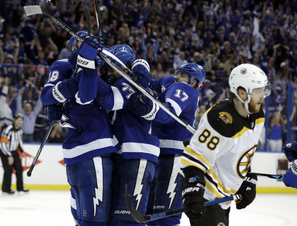 Tampa Bay Lightning defenseman Anton Stralman, left, is mobbed by teammates after scoring against the Boston Bruins during the third period of Game 5 of a second-round playoff series Sunday in Tampa, Florida.