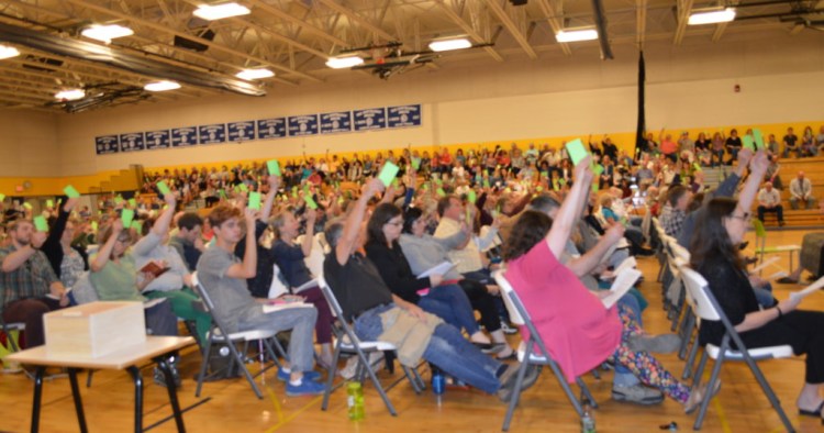 Regional School Unit 9 voters raise green cards to vote "yes" to approve a budget article Tuesday at the Mt. Blue campus in Farmington. The proposed $35.54 million budget now will go to a yes-or-no validation vote Tuesday in each of the 10 district towns.