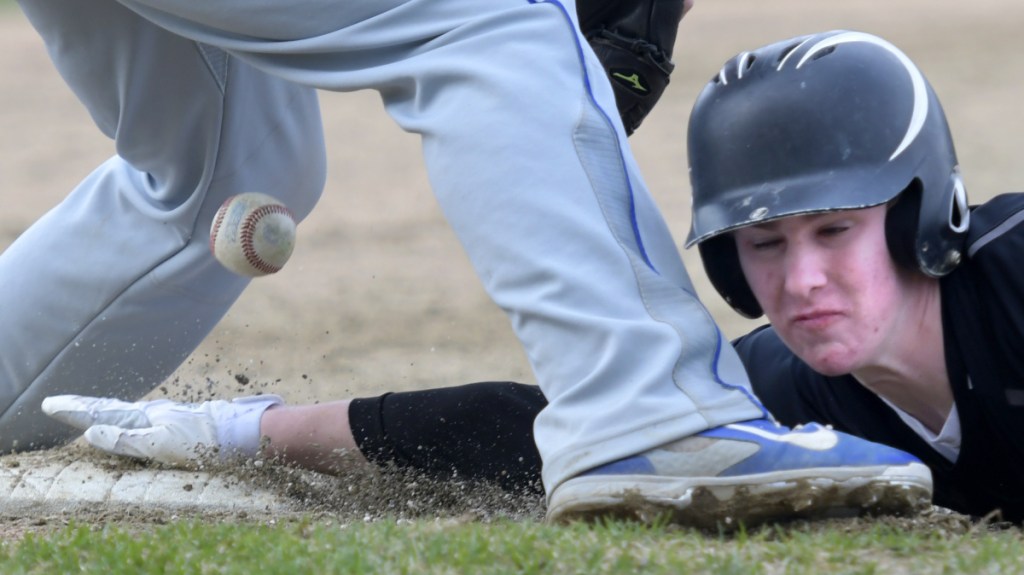 Maranacook's Jarred Schmidt slides into third base beneath a throw to Lawrence's Michenzie Steeves during a Kennebec Valley Athletic Conference game Monday in Readfield.