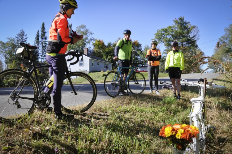 Bicycle Coalition of Maine Executive Director Nancy Grant, left, joins other bicyclists in paying respect to Dr. Carol Eckert in October 2017. Eckert died from injuries suffered in October 2016 when a pickup truck hit her while she was riding near her home in Windsor. The bicycle was painted white, as a "ghost bike," and placed at the site of the accident on Wingood Road.