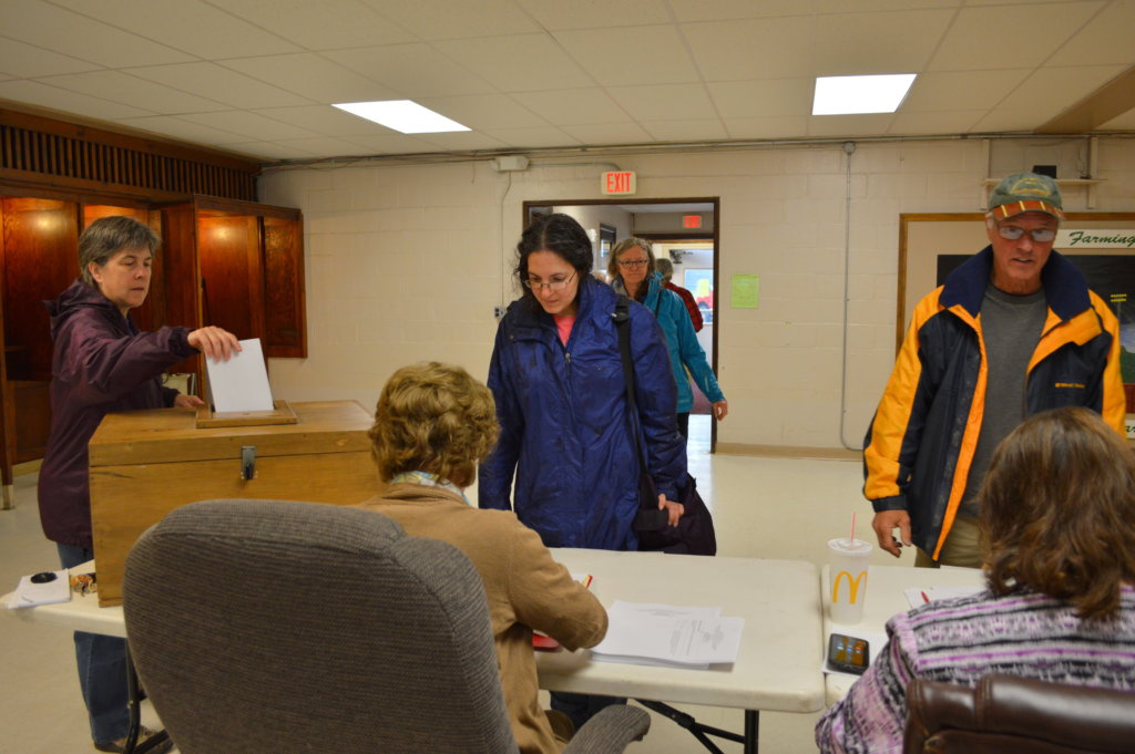 Crystal Woehrle-Logan, of Farmington, center, gets a ballot to vote on the Regional School Unit 9 budget Tuesday at the Community Center in Farmington.