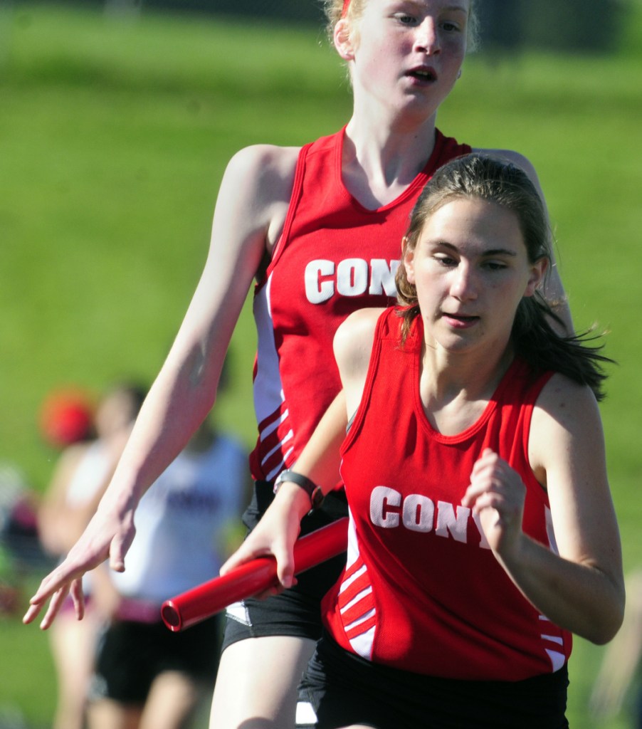 Cony's Cecelia Guadalupi, top, hands off the baton to teammate Ally Waller in the 4x800 relay during the I. Taylor Harmon Capitol City Classic last year at Cony.