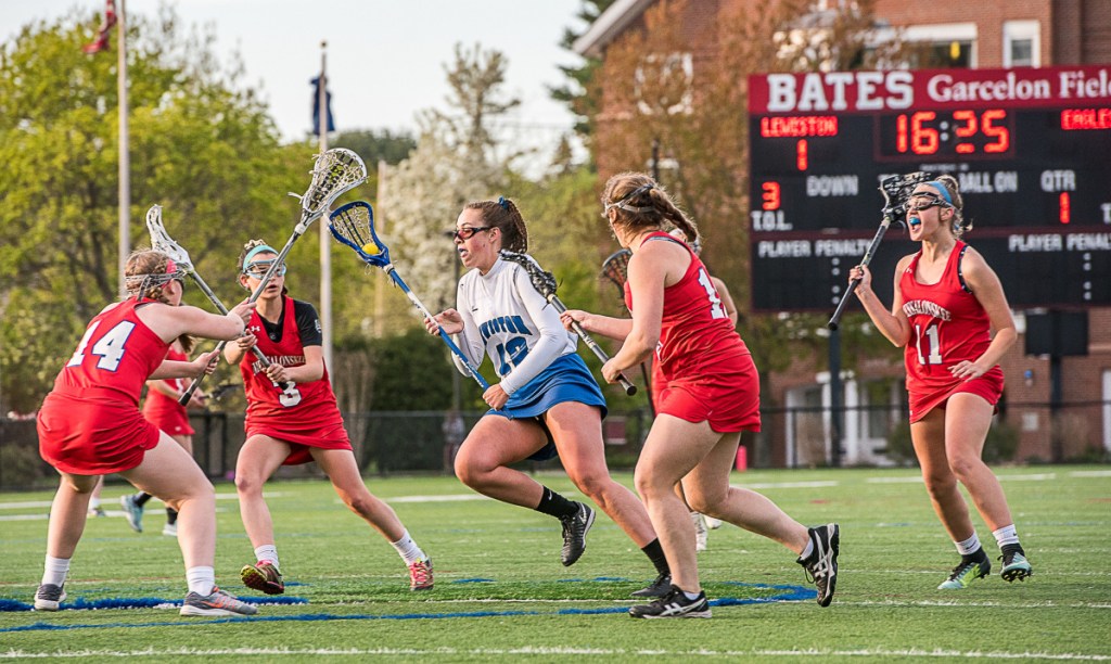 Lewiston's Grace Dumond drives through a sea of Messalonskee players during Wednesday night's lacrosse game at Bates College in Lewiston. From the left are Katie Luce, Chloe Tilley, Emily Crowell and Shauna Clark.