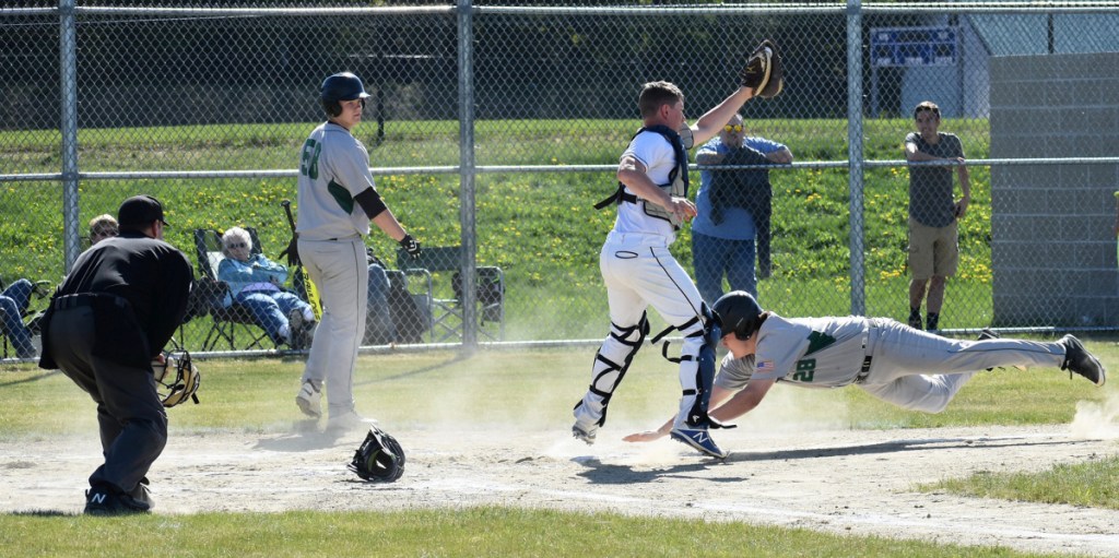Sun Journal photo by Tony Blasi
Leavitt's Allen Peabody dives toward the plate, but is greeted by Mt. Blue catcher Hunter Bolduc for the out.