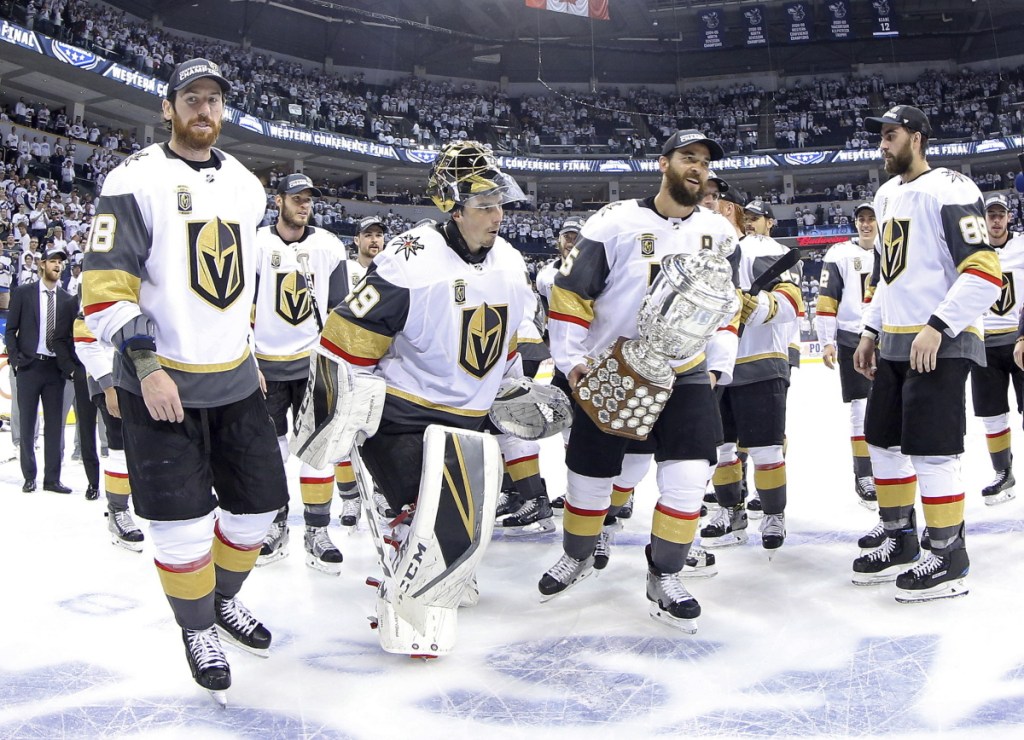Vegas Golden Knights players James Neal (18), Deryk Engelland (5), goaltender Marc-Andre Fleury (29) and the rest of the team celebrate after defeating the Winnipeg Jets during Western Conference Finals on Sunday in Winnipeg.