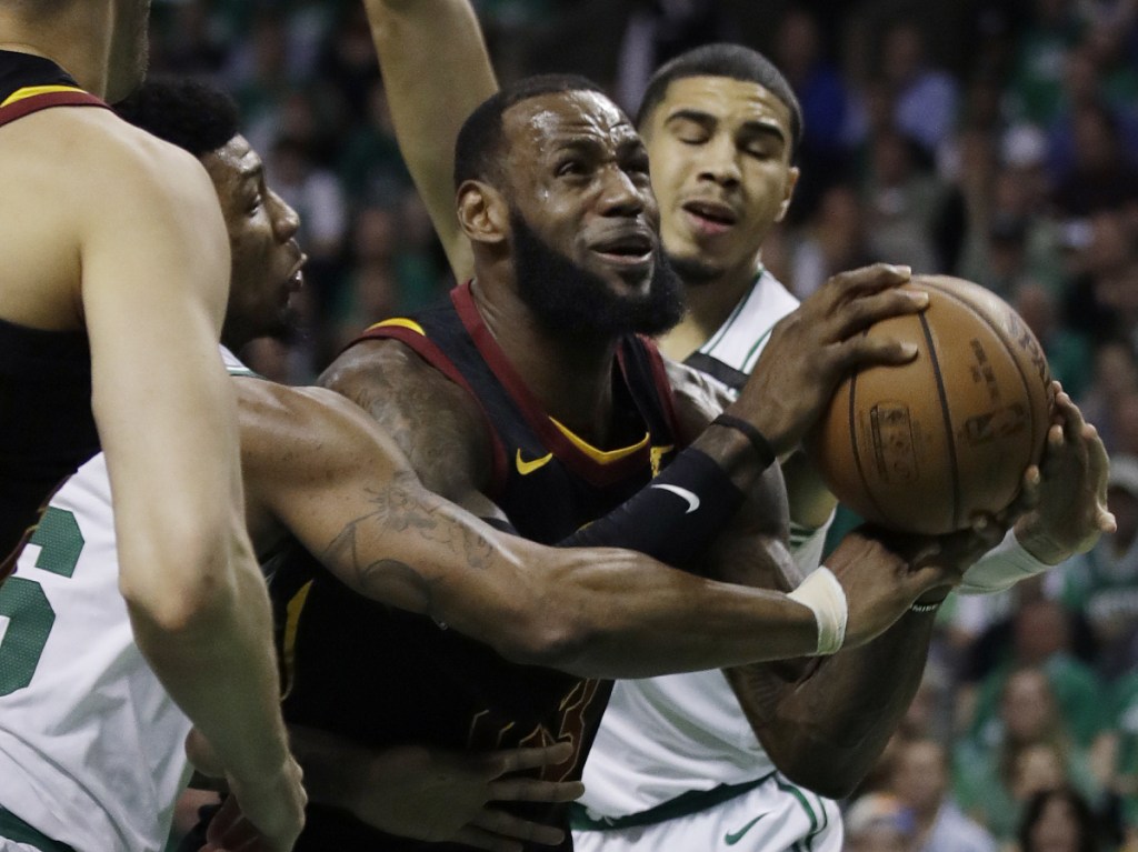 Cleveland Cavaliers forward LeBron James drives against Boston Celtics guard Marcus Smart, left, and forward Jayson Tatum, right, during the first quarter of Game 5 of the Eastern Conference Finals on Wednesday in Boston.