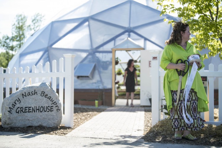 Crista Lavenson stands outside the gates to the new Mary Nash Beaupre Greenhouse at the ceremony marking the opening of the new addition at the Alfond Youth Center on North Street in Waterville on Wednesday.
