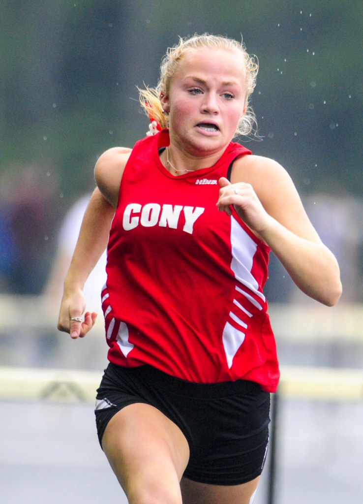 Cony's Anna Reny runs the 300-meter hurdles during a rainy Kennebec Valley Athletic Conference track meet last Saturday at Mt. Ararat High School in Topsham.