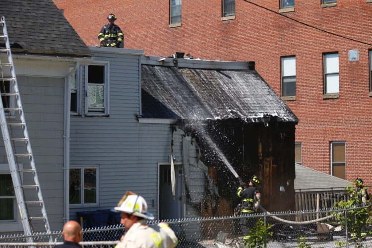 Firefighters work to extinguish a fire at a three-family apartment building on Alder Street in Portland on Tuesday.