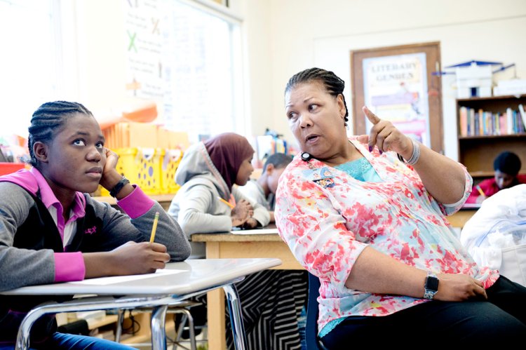 Lewiston Middle School teacher Barbara Benjamin-McManus works with Tatiana Masikini in her English language learners class. Benjamin-McManus is one of two black teachers at LMS. 