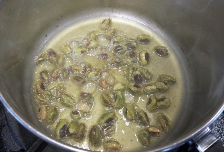 Raw pistachios brown in clarified butter.