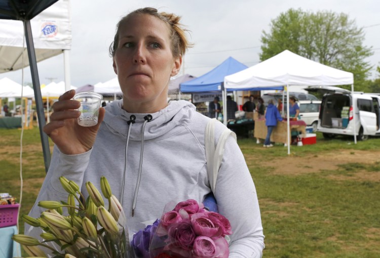 Caitlin Mance of Watertown, Mass., tastes Norumbega hard cider at the Brunswick market. Maine's new law allows makers to offer samples of their alcoholic beverages at farmers markets, which have begun in earnest with the onset of warmer weather.