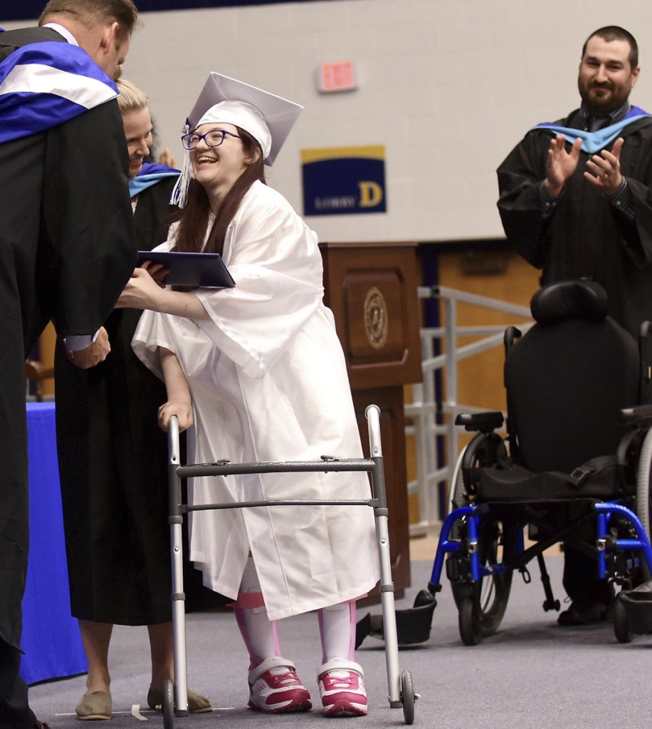 Lexi Wright leaves her wheelchair and walks across the stage to accept her diploma at Ravenna High School's graduation at Kent State University in Kent, Ohio.