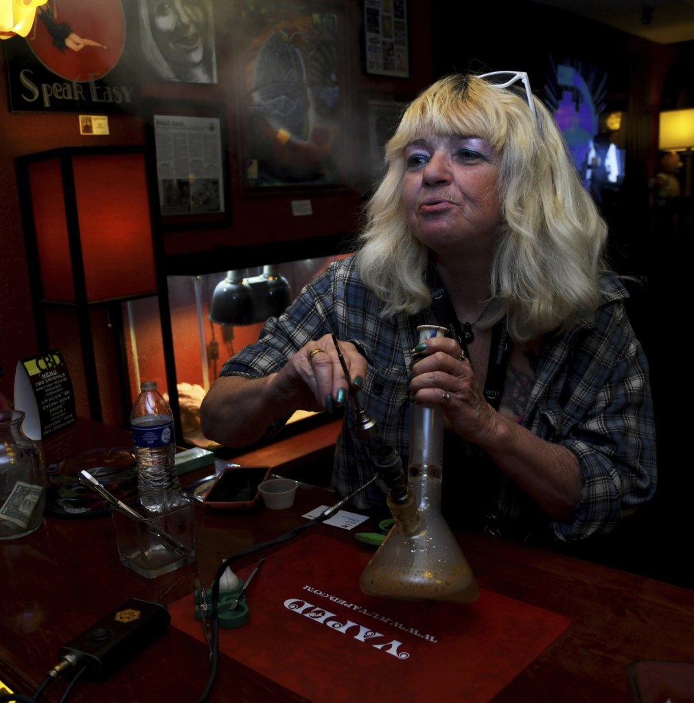 Linda Wood smokes pot at the Speakeasy Vape Lounge in Colorado Springs. The veto of a bill allowing "tasting rooms" means clubs like Speakeasy can keep operating unregulated.